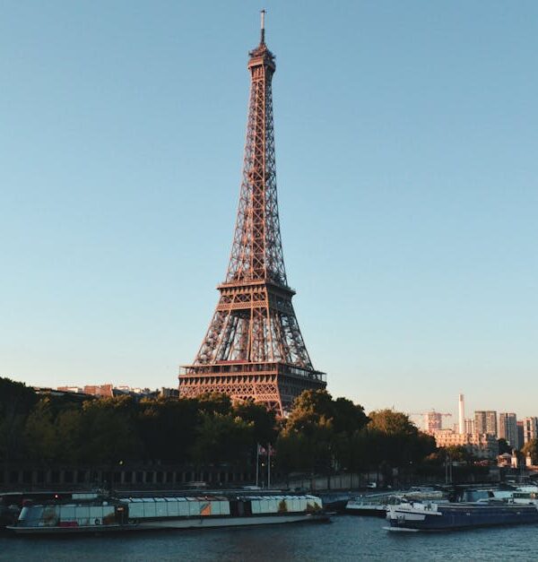 Scenic view of the Eiffel Tower and Seine River at sunset, showcasing iconic Parisian architecture.