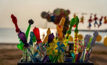 Vibrant children's toys displayed at the beach with a sunset backdrop in Colombo, Sri Lanka.